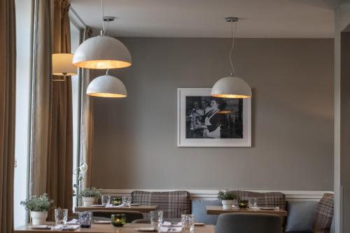 a dining room with tables and chairs and lights at Hotel Haberkamp in Achim