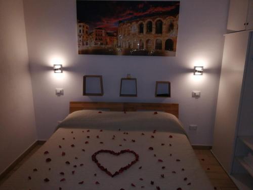 a bedroom with a bed with a heart pillow on it at Vapama Rooms in Verona