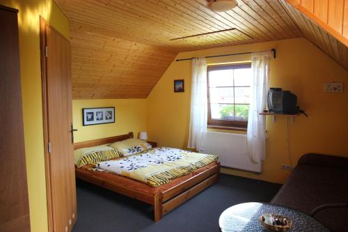 a small bedroom with a bed and a window at Apartmány Černá Voda in Černá Voda