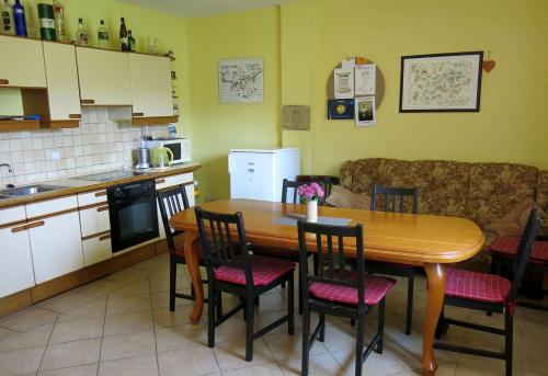 cocina con mesa de madera y sillas en Apartmány Černá Voda, en Černá Voda