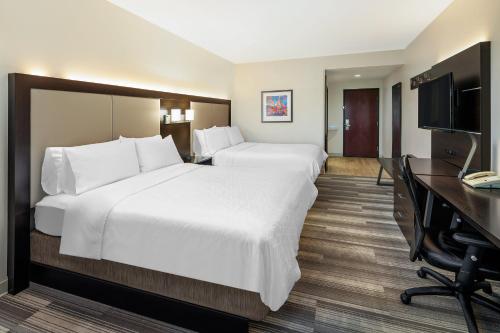 a hotel room with two beds and a desk at Holiday Inn Express & Suites Florence by IHG in Florence