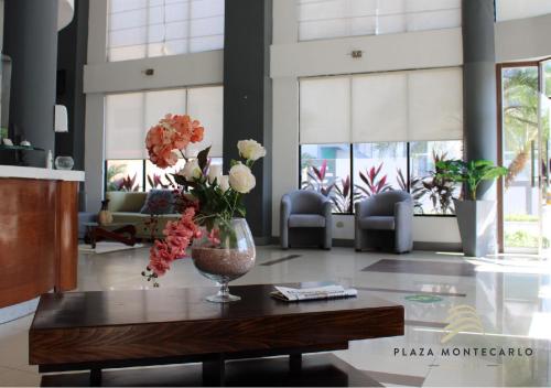 a lobby with a vase of flowers on a table at Hotel Plaza Monte Carlo in Guayaquil