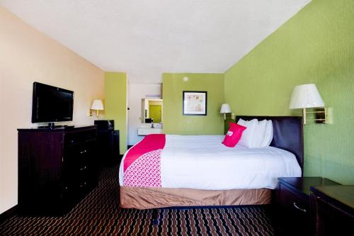 a hotel room with a bed and a flat screen tv at OYO Hotel Pensacola I-10 & Hwy 29 in Pensacola