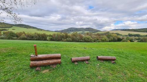 two benches in the middle of a green field at Stredisko Lipka in Bardejov