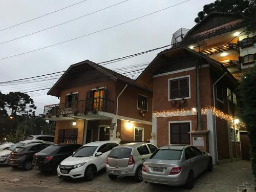 cars parked in front of a house at Pousada da Brigida in Campos do Jordão