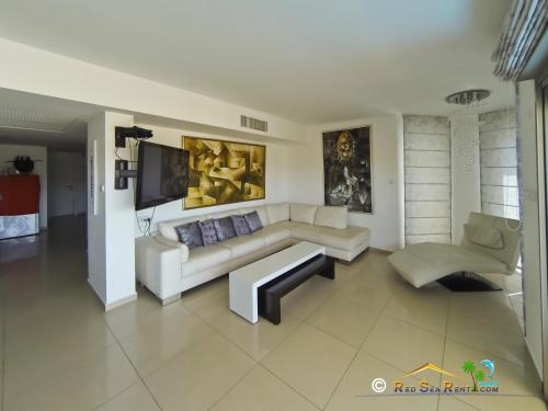 a living room with a couch and a tv at exclusif apartment by the sea in Eilat