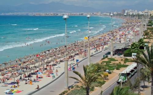 a beach with a lot of people and the ocean at Hotel Hispania in Playa de Palma