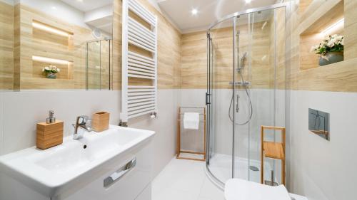 a bathroom with a sink and a shower at Apartament Sarnia Z widokiem na Śnieżkę in Karpacz