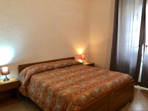 a bedroom with a bed and two lamps on tables at Residenza Pitigliano Gens Petilia - Nuova gestione in Pitigliano