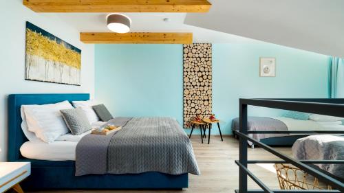 a bedroom with a bed with a blue head board at Apartament Sarnia Z widokiem na Śnieżkę in Karpacz