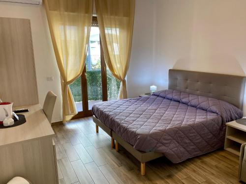 een slaapkamer met een paars bed en een raam bij Caruso Rooms in Sorrento