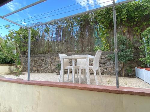 a table and chairs on a patio with a fence at Caruso Rooms in Sorrento