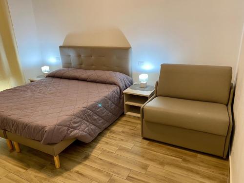 a small bedroom with a bed and a chair at Caruso Rooms in Sorrento