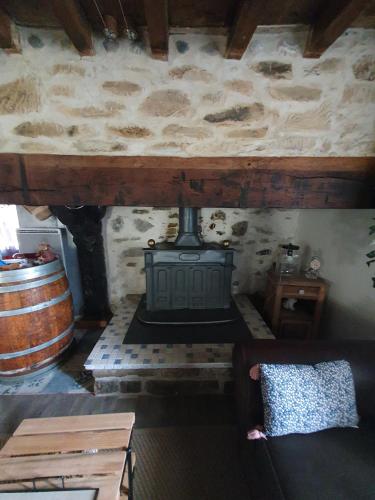 a room with a fireplace and a couch and a barrel at Au Nid de Caroline gîte 4 étoiles in Arette