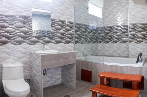 een badkamer met een toilet, een wastafel en een bad bij HOTEL AMERICANO in Jaén