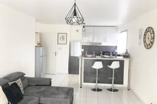 a living room with a couch and a kitchen at Superbe Appartement lumineux proche Disney in Montévrain