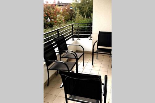 a group of chairs sitting on a balcony at Superbe Appartement lumineux proche Disney in Montévrain