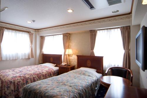 Una cama o camas en una habitación de Beppu Station Hotel