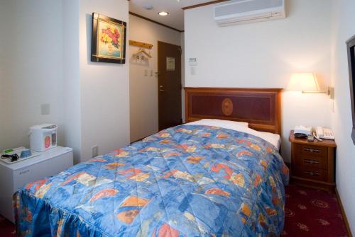Una cama o camas en una habitación de Beppu Station Hotel