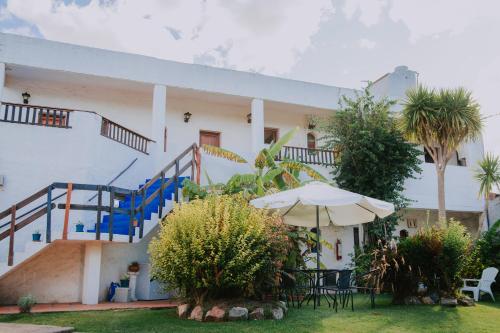a white building with a staircase and an umbrella at Posada del Navegante in Carmelo