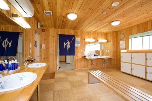 別府市にある別府温泉　別府ステーションホテルの木製の部屋に洗面台2台付きのバスルーム