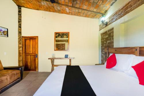 a bedroom with a bed and a table in a room at Capital O Hotel Posada Terraza, Tequila Jalisco in Tequila