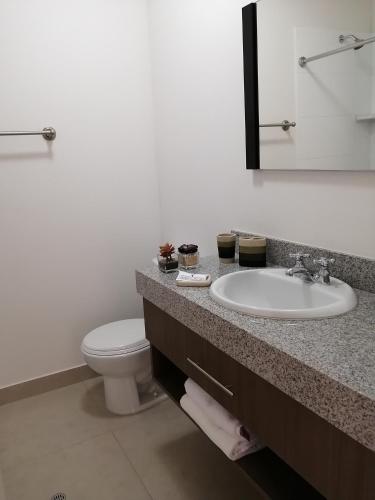 a bathroom with a sink and a toilet at Departamento BH South in Lima