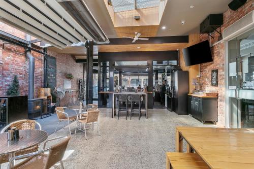 a restaurant with tables and chairs and brick walls at Quality Inn The George Hotel Ballarat in Ballarat