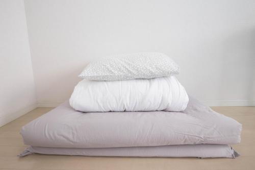 a stack of pillows sitting on top of a bed at Yakuin apartment in Fukuoka