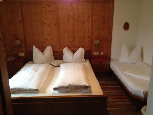 ラムサウ・イム・ツィラータールにあるBichlhofの白い枕付きのベッド2台が備わる客室です。