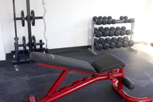 a red bench in a gym with weights at Lujoso y acogedor condominio ejecutivo/familiar in San Pedro Sula