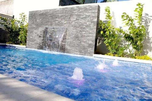 圣佩德罗苏拉Lujoso y acogedor condominio ejecutivo/familiar的两人在带喷泉的游泳池