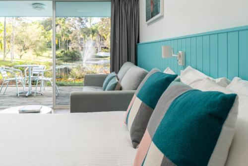 a bedroom with a bed and a living room at The Cubana Resort Nambucca Heads in Nambucca Heads