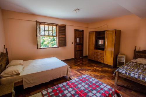 a bedroom with two beds and a window at Hotel Fazenda Morada Do Imperador in Barbacena