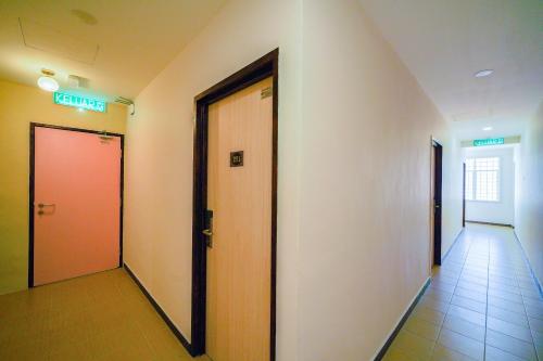 a hallway with two elevators and a red door at CMN Hotel & Homestay in Sungai Petani