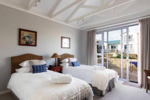 two beds in a bedroom with a view of the ocean at Pinnacle Point Lodge 70 Golf and Spa Estate in Mossel Bay
