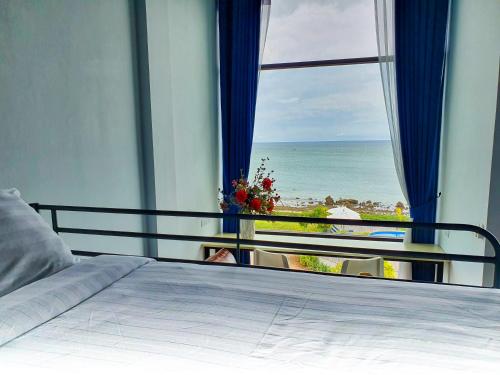 a bedroom with a bed and a view of the ocean at The Beach Resort & Residence - SHA Plus in Pathiu