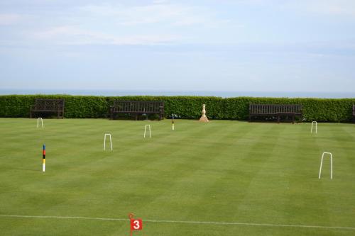 a lawn with benches and a statue in the middle at Hydro Hotel in Eastbourne