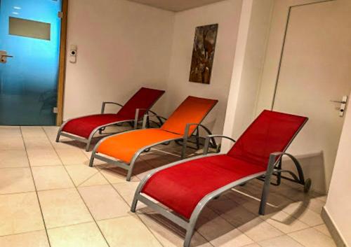 three chairs in a waiting room with orange seats at Ferienwohnung in den Bergen mit grosser Terrasse in Bivio