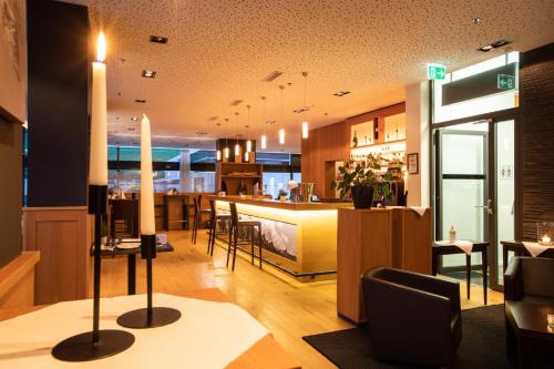 a restaurant with a bar and a dining room at Mercure Chur City West in Chur