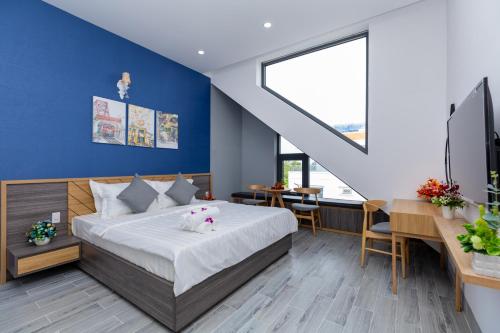 1 dormitorio con cama y pared azul en Palm Villa 11 - Luxury Pool Villa 8Rooms , Bida, Hồ Bơi, Gần Biển, en Xã Thang Tam
