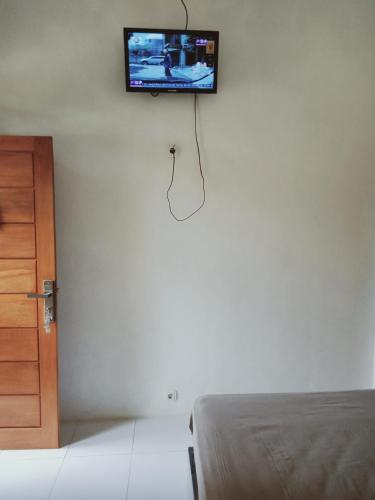 a tv hanging on a wall in a bedroom at Griya PAS Pangandaran in Pangandaran