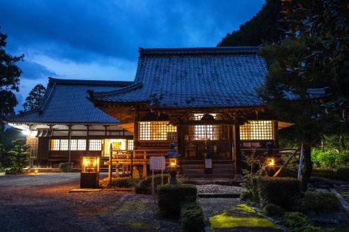 un bâtiment avec des lumières devant lui la nuit dans l'établissement 宿坊 大泰寺 Temple Hotel Daitai-ji, à Shimosato