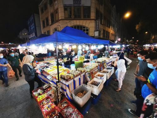 a group of people standing around a market at night at Good2Stay Budget Hotel l Lift l Coway Water l WIFI6 l Laundromat in Melaka