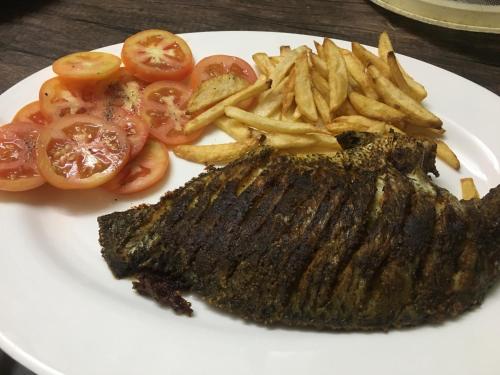 a plate of food with a steak and french fries at Marari Dreamz Homestay in Mararikulam
