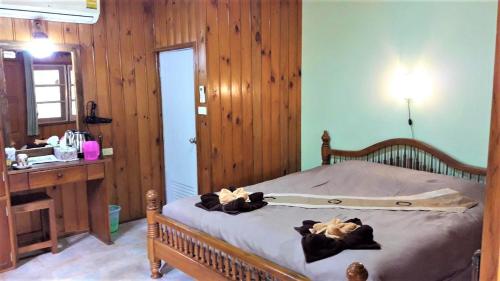 a bedroom with a bed with towels on it at Huan Chiang Dao Resort in Chiang Dao