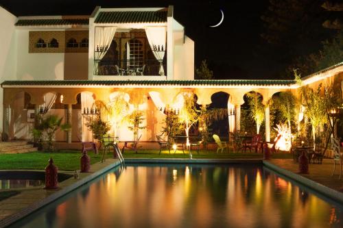 une maison avec une piscine la nuit dans l'établissement Villa Des Ambassadors, à Rabat