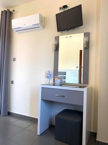 a room with a blue desk with a mirror at Αφροδίτη Hotel in Néon Rýsion