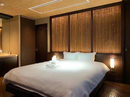 a large white bed in a room with windows at Gion Suite in Kyoto