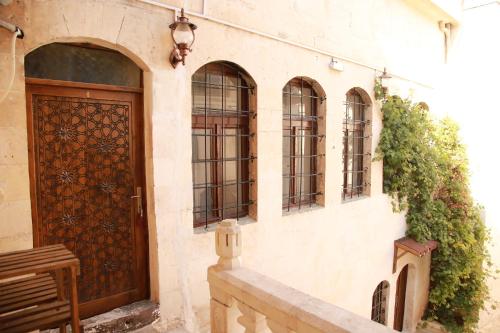 a building with a wooden door and some windows at Aslan Guest House in Sanlıurfa